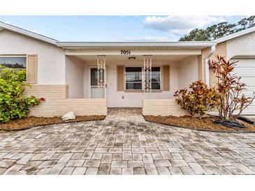 Inviting home exterior with a brick facade and landscaped walkway at 7051 Nova Scotia Dr, Port Richey, FL 34668