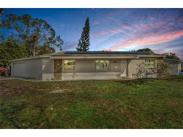 Single-story home with solar panels and a well-maintained lawn at 8001 70Th N St, Pinellas Park, FL 33781