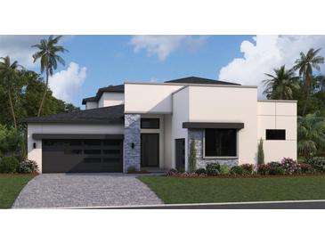 Modern two-story home with dark gray garage door and stone accents at 8421 Golden Beach Ct, Parrish, FL 34219