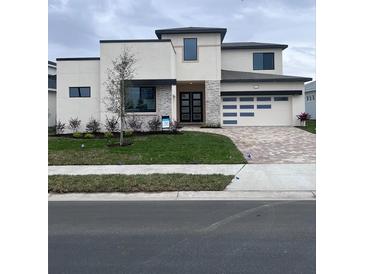 Two-story modern home with a gray roof and light-colored exterior, featuring a three-car garage at 8421 Golden Beach Ct, Parrish, FL 34219