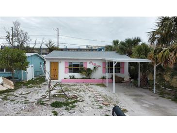 Charming single-story home with pink accents and a carport at 14236 Palm St, Madeira Beach, FL 33708