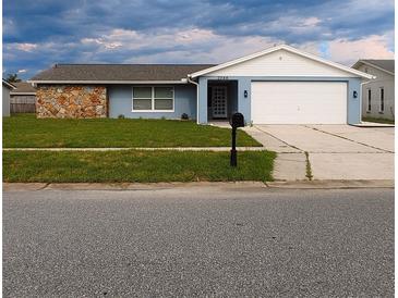 Ranch style home with stone accents and a two-car garage at 2048 Tumbleweed Dr, Holiday, FL 34690