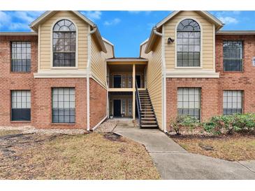 Attractive two-story condo building with brick and siding exterior, stairs, and landscaping at 8647 Fancy Finch Dr # 203, Tampa, FL 33614