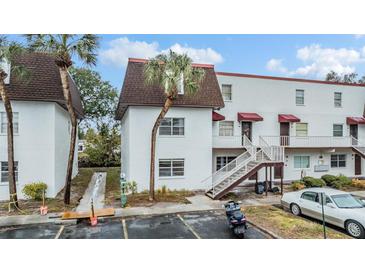 Two-story condo building with a brown roof and white exterior at 9119 Tudor Dr # E201, Tampa, FL 33615