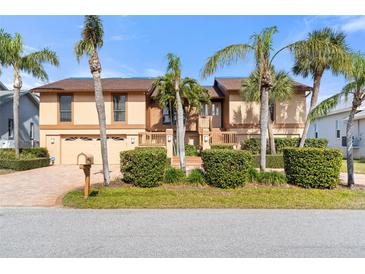 Two-story house with a double garage and palm trees at 127 6Th E St, Tierra Verde, FL 33715