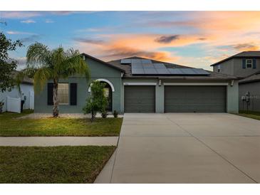 Two-story house with solar panels and a three-car garage at 13580 Willow Bluestar Loop, Riverview, FL 33579
