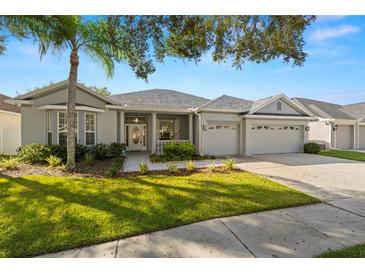 Single-story home with a two-car garage and landscaped lawn at 15214 Octavia Ln, Odessa, FL 33556