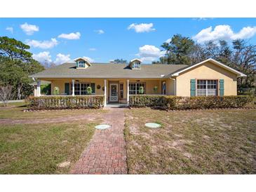 Single-story home with a large front porch and well-manicured lawn at 17852 Fancy Ln, Hudson, FL 34667