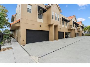 Tan building with multiple garages and private parking at 3210 W Horatio St # 1, Tampa, FL 33609