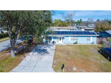 Aerial view of a single-story home with solar panels and a spacious driveway at 5481 65Th N Ave, Pinellas Park, FL 33781