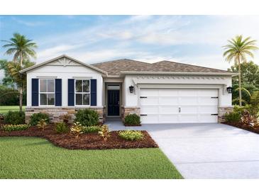 One-story home with a two-car garage, landscaping, and shutters at 7815 Wheat Stone Dr, Zephyrhills, FL 33540
