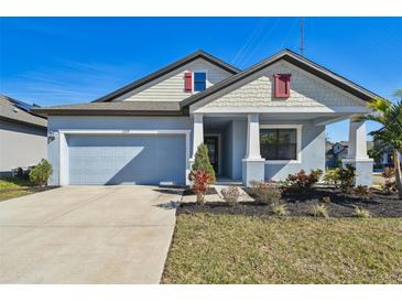 Newly built home with light blue exterior, landscaping, and a two-car garage at 12119 Creek Preserve Dr, Riverview, FL 33579