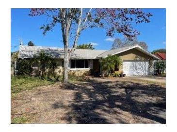 Charming single-story home with mature landscaping, a well-manicured yard, and an attached garage at 1700 Kay Dr, Largo, FL 33770