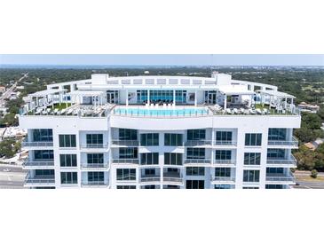 Aerial view of luxury condo building with rooftop pool and city views at 2910 W Barcelona St # Ph-2302, Tampa, FL 33629