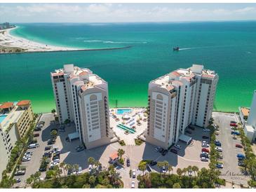 Aerial view of a beachfront property with two towers, pool, and ample parking at 450 Gulfview S Blvd # 1708, Clearwater, FL 33767