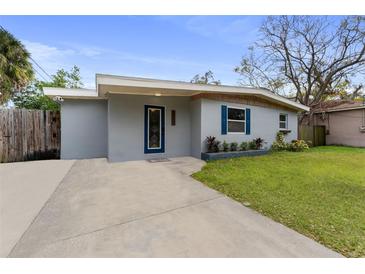 Updated home exterior with gray siding, a new driveway and landscaping at 6405 Julie St, Tampa, FL 33610