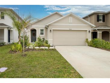 House exterior features a two-car garage and well-manicured lawn at 9228 Forge Breeze Loop Loop, Wesley Chapel, FL 33545