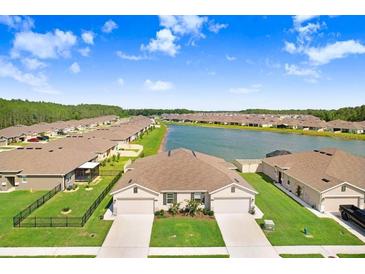 Aerial view of two-story home with lake access in a new community at 18058 Turning Leaf Cir, Land O Lakes, FL 34638