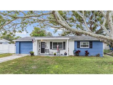 Charming ranch home with blue exterior, covered porch, and well-maintained lawn at 3303 Bainbridge Dr, Holiday, FL 34691