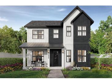 Two-story modern farmhouse with black and white exterior, landscaping, and walkway at 3640 15Th N St, St Petersburg, FL 33704