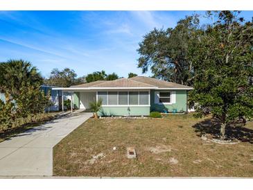 Charming ranch home with a light green exterior, and a well-maintained lawn at 436 Norfolk St, Dunedin, FL 34698