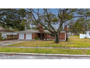 Brick house with two-car garage and mature landscaping at 4646 W Longfellow Ave, Tampa, FL 33629