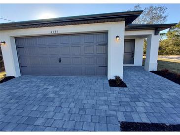 Modern home with attached two-car garage and paver driveway at 5402 Ojus St, North Port, FL 34286