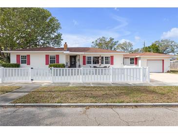 Charming mid-century home with white picket fence and red accents at 600 30Th N St, St Petersburg, FL 33713