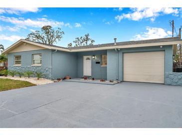 Newly painted light blue home with a 1-car garage, landscaped lawn, and paved driveway at 9100 52Nd N Way, Pinellas Park, FL 33782