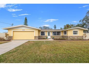 Ranch style home with attached garage and landscaped lawn at 1243 Bayshore Dr, Terra Ceia, FL 34250