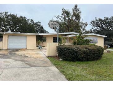 Ranch style home with carport, basketball hoop, and mature landscaping at 1373 Fairfax Rd, Clearwater, FL 33764