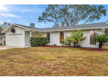 Ranch style home with attached garage and landscaped lawn at 1753 Lucas Dr, Clearwater, FL 33759