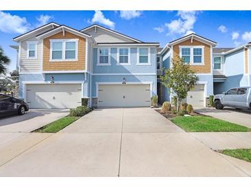 Three-unit townhome building with two-car garages and landscaped front yards at 17806 Althea Blue Pl, Lutz, FL 33558