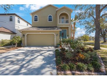 Two-story house with a two-car garage and nicely landscaped front yard at 7418 S Morton St, Tampa, FL 33616