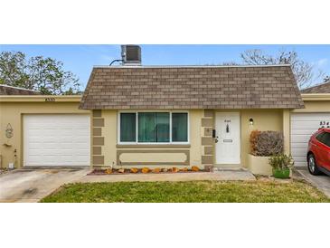 Front view of a single-story house with a garage and well-maintained lawn at 8330 Vendome N Blvd # X, Pinellas Park, FL 33781