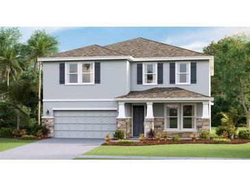 Two-story house with gray siding, stone accents, and a two-car garage at 10826 Patoka Ter, Parrish, FL 34219