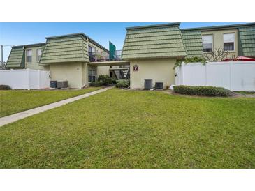 Exterior view of condo building with green roof and walkway at 1799 N Highland Ave # 136, Clearwater, FL 33755