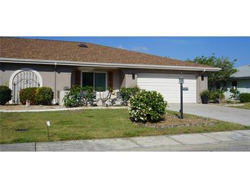 Well-maintained house with a landscaped lawn, attached garage, and attractive curb appeal at 317 Green Manor Dr # 38 B, Sun City Center, FL 33573