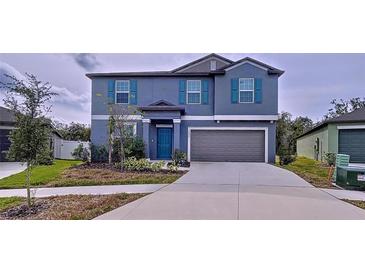 Two-story house with gray siding, teal door, and two-car garage at 13455 Jamaica Plank Loop, Riverview, FL 33579