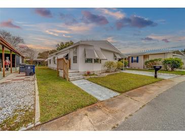 Mobile home exterior, nicely landscaped with a walkway and driveway at 148 Gull Aire Blvd, Oldsmar, FL 34677