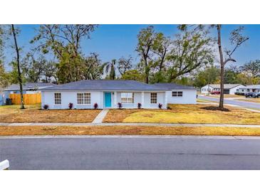 Newly renovated home with a modern exterior and a teal front door at 2901 Forestwood Dr, Seffner, FL 33584