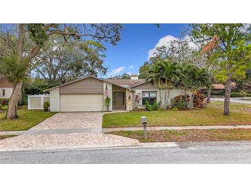 Attractive single-story home with landscaped yard and brick driveway at 3005 Enisglen Dr, Palm Harbor, FL 34683