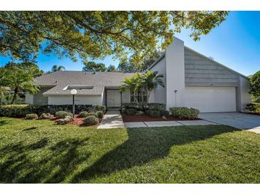 Single story home with gray siding, landscaping, and a two-car garage at 3147 Hyde Park Dr, Clearwater, FL 33761