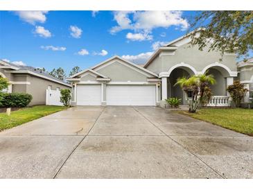 Two-story house with a three-car garage and manicured lawn at 4337 Waterford Landing Dr, Lutz, FL 33558