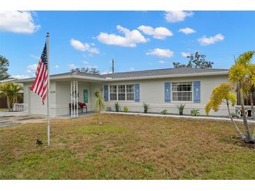 Charming single story home with a manicured lawn and American flag at 5871 49Th N Ave, Kenneth City, FL 33709