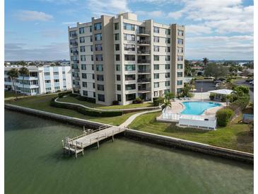 Drone view of waterfront condo building with pool and private pier at 750 Island Way # 401, Clearwater Beach, FL 33767