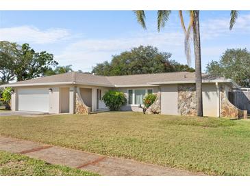 Ranch-style home with a large yard and attached garage at 13561 105Th Ave, Largo, FL 33774