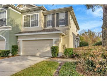 Two-story townhome with attached garage and manicured landscaping at 2104 Park Crescent Drive, Land O Lakes, FL 34639