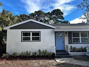 Updated brick home with light blue door and landscaping at 2318 Granada W Cir, St Petersburg, FL 33712