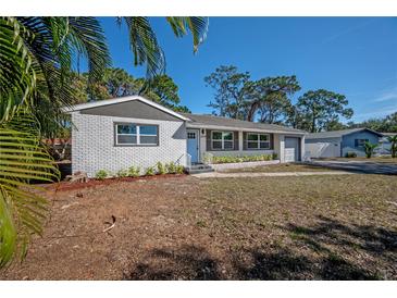 Newly renovated single story home with white brick exterior and landscaped yard at 2318 Granada W Cir, St Petersburg, FL 33712